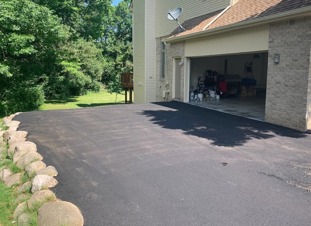New asphalt driveway up to an attached garage